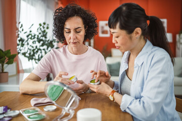 female friends share skincare moment use face cream relax together