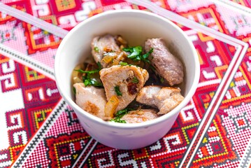 stewed meat with herbs on an embroidered tablecloth