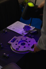 Mechanical engineer using a 3d scanner emitting purple laser beams to measure a precision engineered component, showcasing advanced metrology techniques