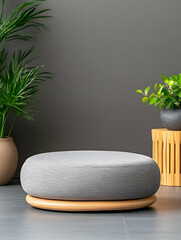 Gray fabric round ottoman on wooden base, minimalist interior setting
