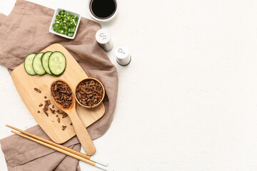 Wooden bowl with fried insects, slices of cucumber and soy sauce on white background