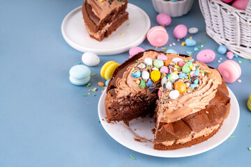 Easter Egg Nest Chocolate Cake. Sweet Easter cake with crushed chocolate eggs, traditional holiday baking recipe idea, on festive decorated table copy space