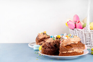 Easter Egg Nest Chocolate Cake. Sweet Easter cake with crushed chocolate eggs, traditional holiday baking recipe idea, on festive decorated table copy space