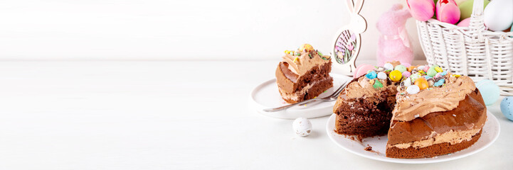 Easter Egg Nest Chocolate Cake. Sweet Easter cake with crushed chocolate eggs, traditional holiday baking recipe idea, on festive decorated table copy space