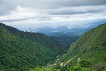 A winding road leading to the village is adorned with green hills.