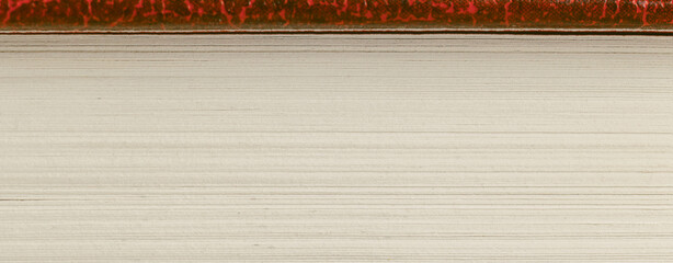 The image shows a close-up of a cream-colored book's edge, with neatly stacked pages and a smooth...