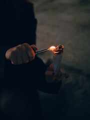 Setting fire to paper with a lighter in the dark
