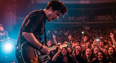 man playing guitar at a live concert with vibrant audience