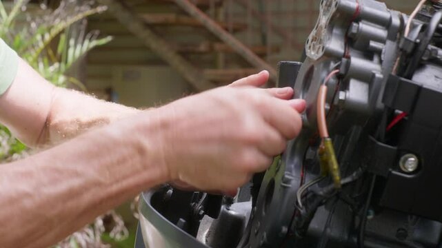 Boat outboard motor maintenance by an Australian Caucasian male. Fitting engine cover, clip 27
