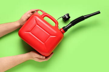 Male hands holding canister with rubber nozzle on green background