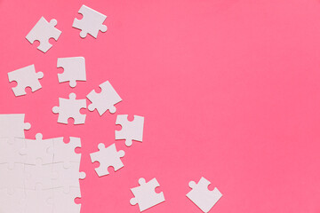 White puzzle pieces on pink background. Autistic disorder concept