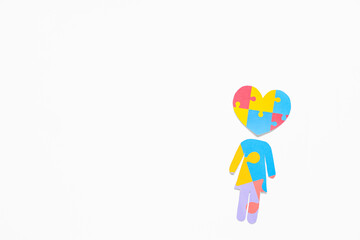 Human figure and heart made of colorful puzzle pieces on white background. Concept of autistic disorder