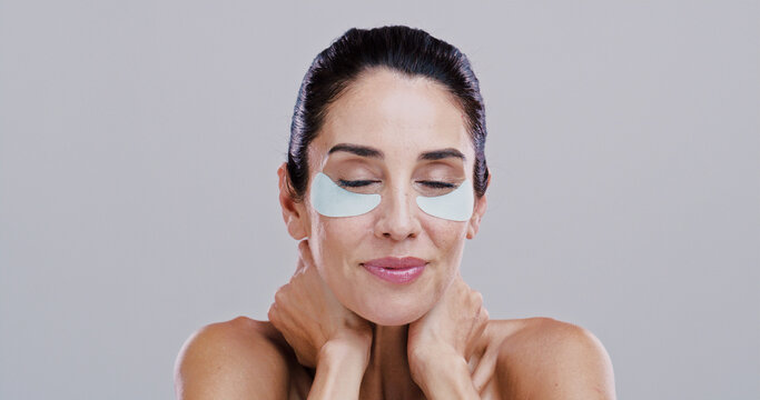 Beauty, skincare and woman with eye patches in studio for collagen treatment, puffiness reduction and self care. Mockup space, mature person and cosmetics product for anti aging on white background