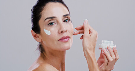 Cosmetics, skincare and woman with face cream in studio for anti aging treatment, wrinkle reduction or retinol. Space, mature person and portrait with beauty product for hydration on white background