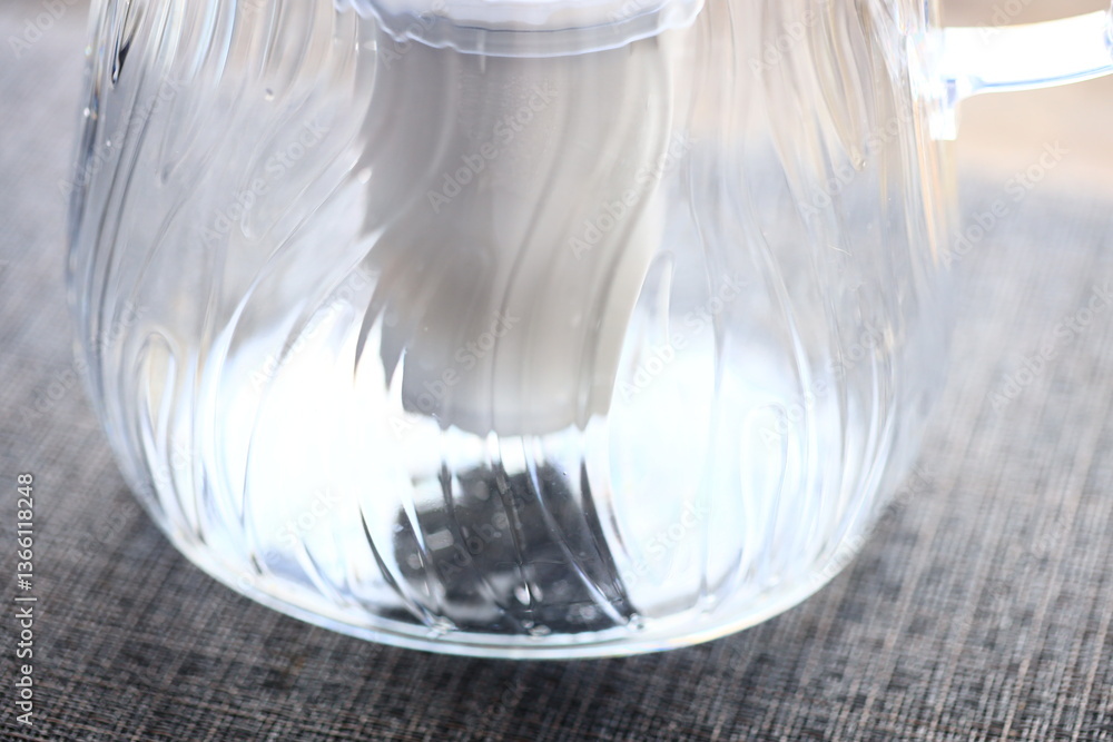 Poster a still life image of a pitcher filled with water sitting on a table, perfect for commercial or edit