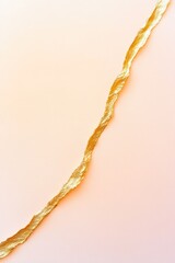 Fototapeta premium delicate thread of gold running diagonally across muted neutral background