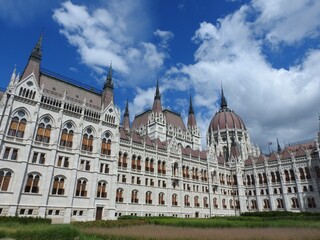 Hungarian Parliament Building in Budapest, an iconic neo-Gothic masterpiece with intricate details and red dome, captured under a vivid blue sky. National symbol of Hungary