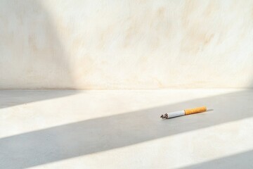 solitary unlit cigarette lies abandoned on large empty white surface symbolizing choice of life over addiction bathed