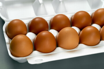 Full white container box of farm fresh brown chicken eggs.