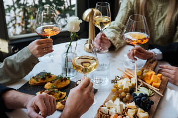 Friends having a dinner party with different kinds of appetizers and wine.