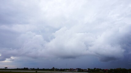 The cloudy afternoon sky with black clouds clumping together is a sign that it will rain, suitable for a background