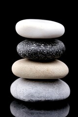 Fototapeta premium Stacked zen stones in harmonious balance against a deep black backdrop