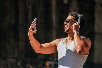 latino man with headphones and cell phone