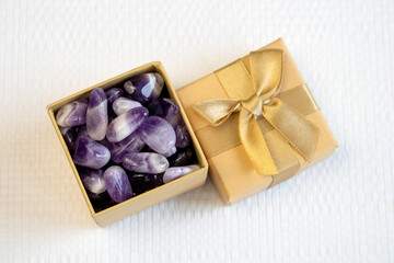 Set of various amethyst natural mineral stones and gemstones on purple background partial focused