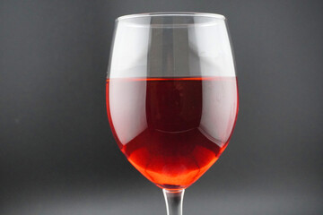 Colored water dropping into a wine glass filled with water.