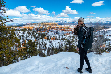 Beautiful hiker in front of panorama landscape of pinnacles of Bryce Canyon National Park covered in snow, Utah USA