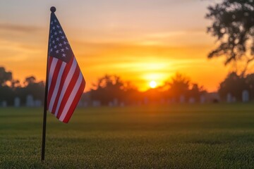 Small american flag waving in the wind at sunrise in a military cemetery