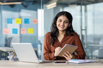 Portrait of a successful female office worker. Businesswoman smiling and looking at the camera with...