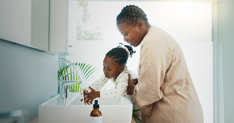 Fototapeta premium Hygiene, helping and black mother with kid for washing hands in bathroom for learning. Happy, teaching and African mom with girl for cleaning skin for prevention of bacteria, dirt or dust in home.