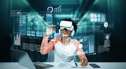 Girl using laptop and augmented glasses connecting metaverse while doing homework at table with...