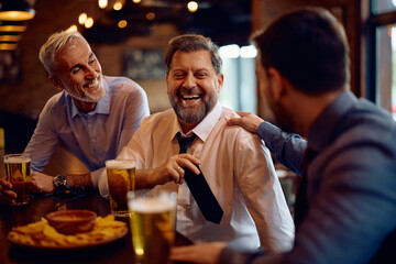 Happy business colleagues having fun after work in bar.