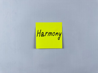 Sticky note with the word Harmony written on it, pinned on white background. Photo symbolizes peace, balance, and unity. Ideal for illustrating concepts of harmonious relationships and balanced life