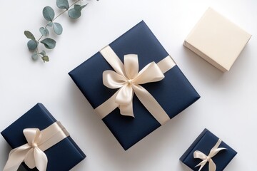 Elegant navy blue gift boxes with beige ribbons, arranged on a white background with eucalyptus sprigs.