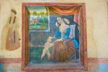 Old painting painted in wall niche in Ali Qapu Palace, Isfahan, Iran. Painting depicts woman in European clothing from early 17th century and figure of child. Unfortunately, some details lost in ages