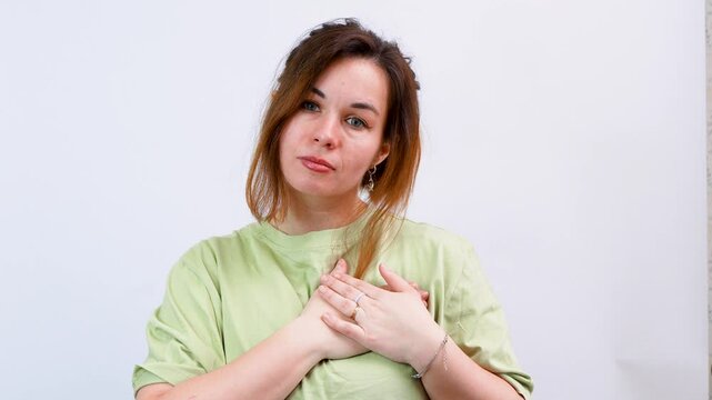 A young woman amiably shows you in my heart against an isolated background