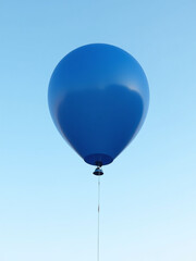 Obraz premium A Navy Blue Balloon Floats Gently In The Air, Its Vibrant Color Standing Out Against A Clear Sky Background.
