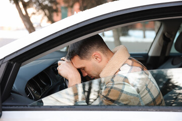 Tired driver sleeping on steering wheel in car, view from outside