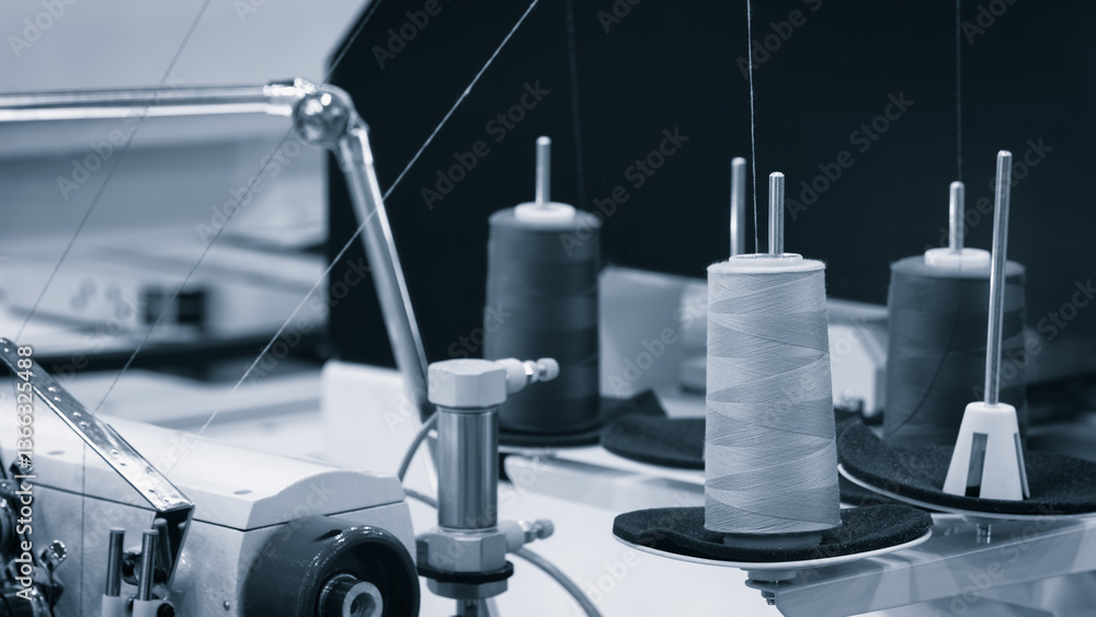 Aufkleber a sewing machine with a spool of thread on it. the spool is white and the machine is black