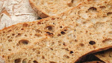 slice of bread with holes in it. The bread is brown and has a crust. The bread is cut in half and...