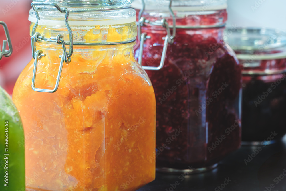 Poster a row of jars with different colored jams, including orange, purple, and green. the jars are lined u