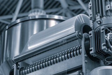 A machine with a roll of polyethylene plastic film on it. The machine is in a factory. industrial...