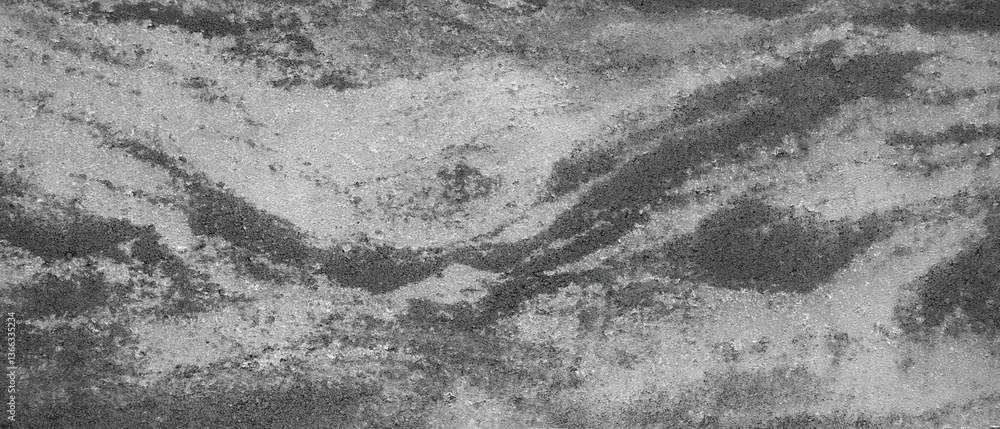 Aufkleber A black and white photo of a rocky shoreline with a wave pattern. The image has a moody and somewhat ominous feel to it, as if it were taken in the dead of night