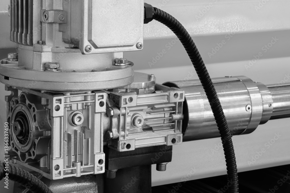 Aufkleber A machine with a silver and black casing. The casing is attached to a black cable. The machine is in a factory setting