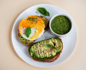 Balanced breakfast with egg, avocado and herbs. Bruschetta with sauce, egg and avocado.