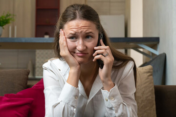 Young woman looking concerned while receiving upsetting news during phone call, her face showing worry and stress as she listens intently
