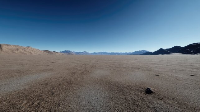 Vast, sun-drenched desert landscape stretches to distant mountains under a clear blue sky.  